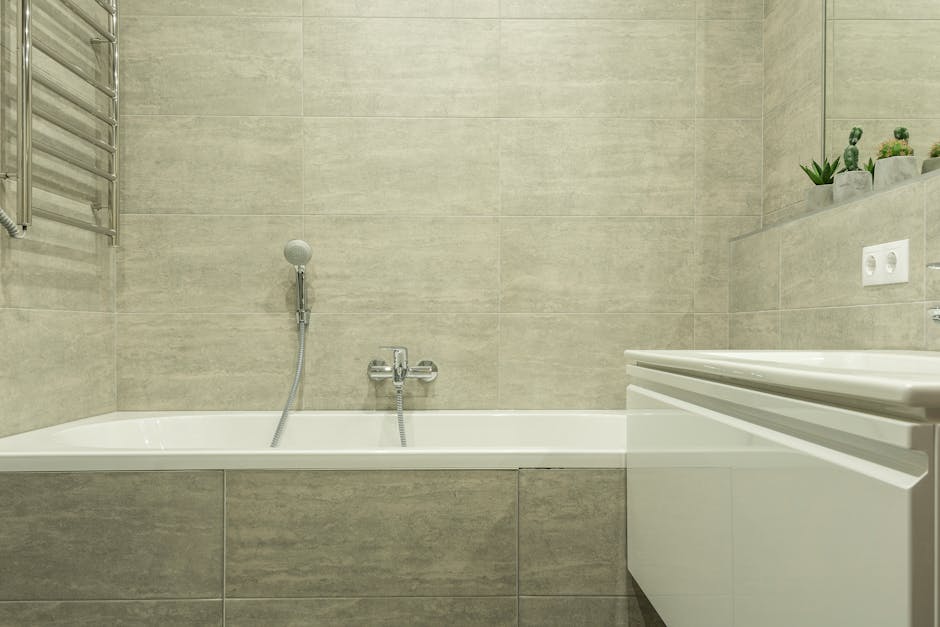 A clean and modern bathroom interior showcasing a ceramic bathtub and stylish tiles.